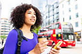 Happy woman with curly hair and multiethnic look in the city