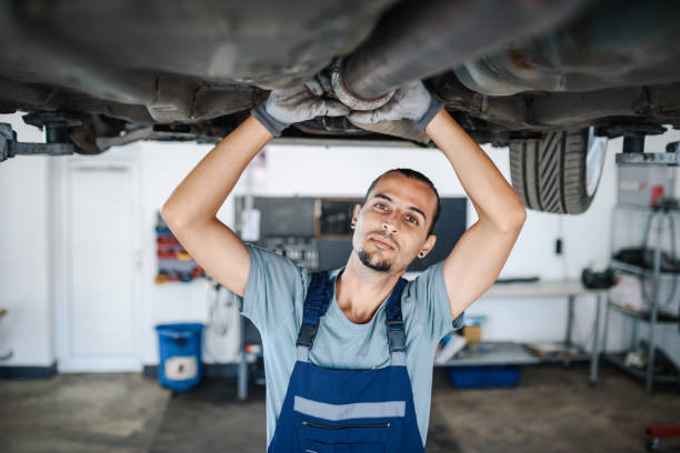 車の足回りで作業するプロの自動車整備士 - coveralls professional occupation manual worker service occupation ストックフォトと画像