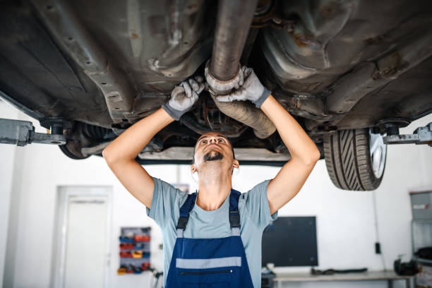 車の足回りで作業するプロの自動車整備士 - coveralls professional occupation manual worker service occupation ストックフォトと画像