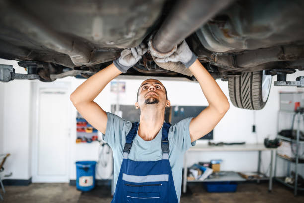 車の足回りで作業するプロの自動車整備士 - coveralls professional occupation manual worker service occupation ストックフォトと画像