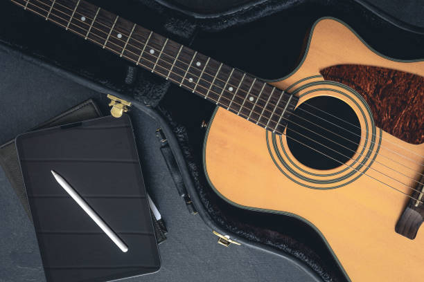 istock Acoustic guitar in a protective case and a digital tablet, top view. 1830698979