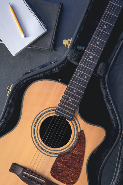 istock Acoustic guitar and notepad with pencil, top view. 1830699101