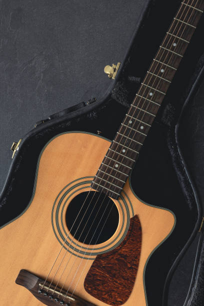 istock Acoustic guitar in a protective case on a dark background, top view. 1830699211