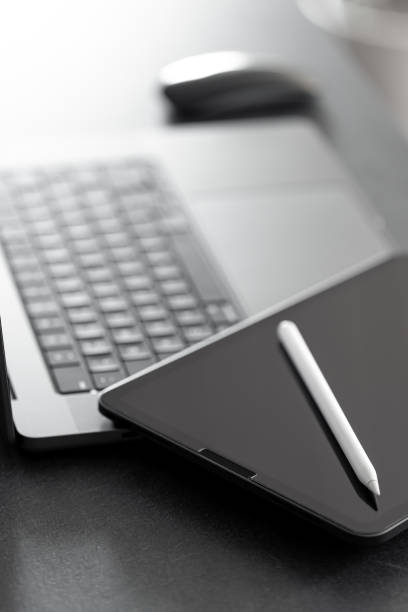 istock Digital tablet, stylus pen and laptop on the desktop, close up. 1830699799