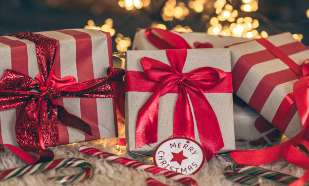 istock Christmas gift boxes with red ribbons close-up. 1830712653