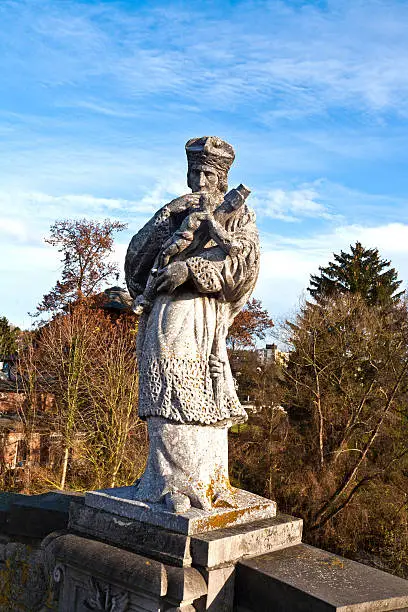 statue of a bishop with a cross with jesus christ at a bridge over river lahn in Limburg