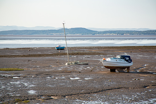 A small boat slowly sinks into the mud over years of abandonment in Morecambe