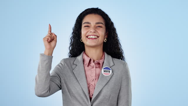Woman, pointing up and advertising for politics and vote, election info and campaign on blue background. News, announcement and presentation, mockup and portrait with political party choice in studio