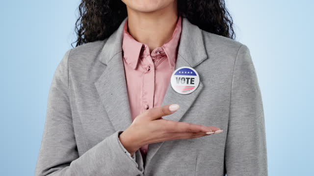 Woman in studio with campaign to vote, badge and hand showing choice for government support. Politics, voting register and decision, politician with pin and election motivation on blue background.