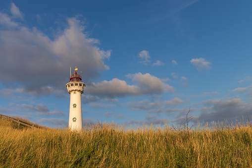 Historical white lighthouse of the dutch coastal village Egmond aan zee at the North Sea.