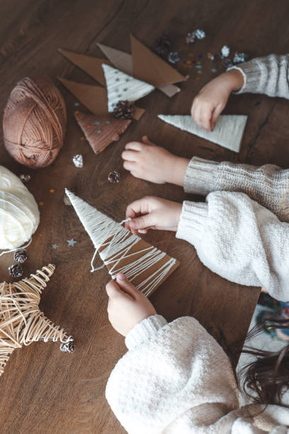 istock Child makes Christmas decoration from yarn 1830768655