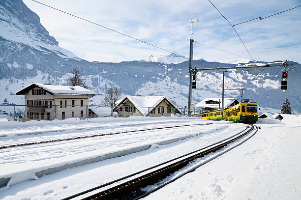 le train arrive en hiver, grindelwald, en suisse - snow european alps house grindelwald photos et images de collection