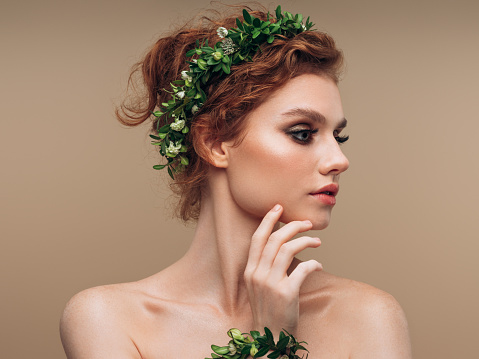 Young beautiful girl with wreath of flowers on the head
