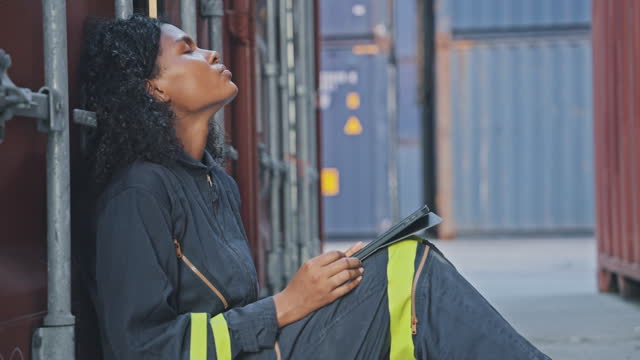 Woman Sitting and Taking a Rest from Fatigue at Work at a Container Terminal