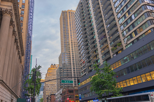 New York, NY, USA - June 10, 2018: view of the iconic architecture of New York city in the USA showcasing the famous Times Square with its neon lights, stores, and restaurants with lots of locals and tourists passing at night.