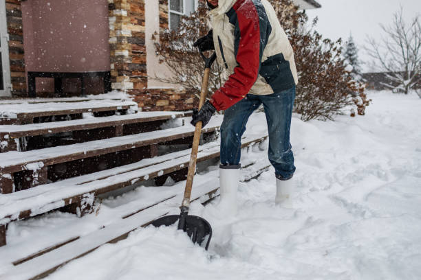 Uomo adulto che rimuove la neve dal portico usando la pala - foto stock