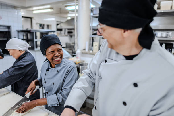 istock Colleagues talking while chopping food in a commercial kitchen 1830824239
