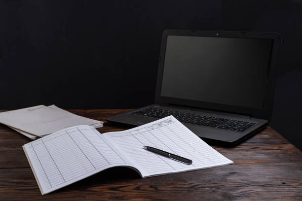 istock Financial notebook on the table and laptop nearby. Notebook and pen on the table. Maintaining records and finances. Planning and tasks. 1830828029