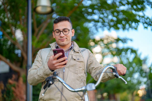 istock Man using mobile phone and bike in the city 1830840864