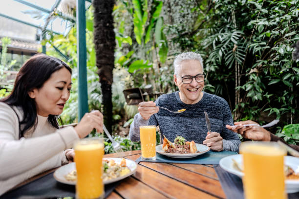 istock Friends talking and eating at restaurant 1830850458