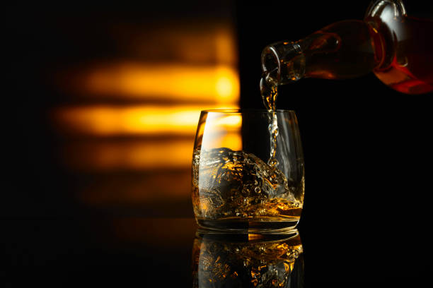 istock Pouring whiskey from a bottle into a glass. 1830853176