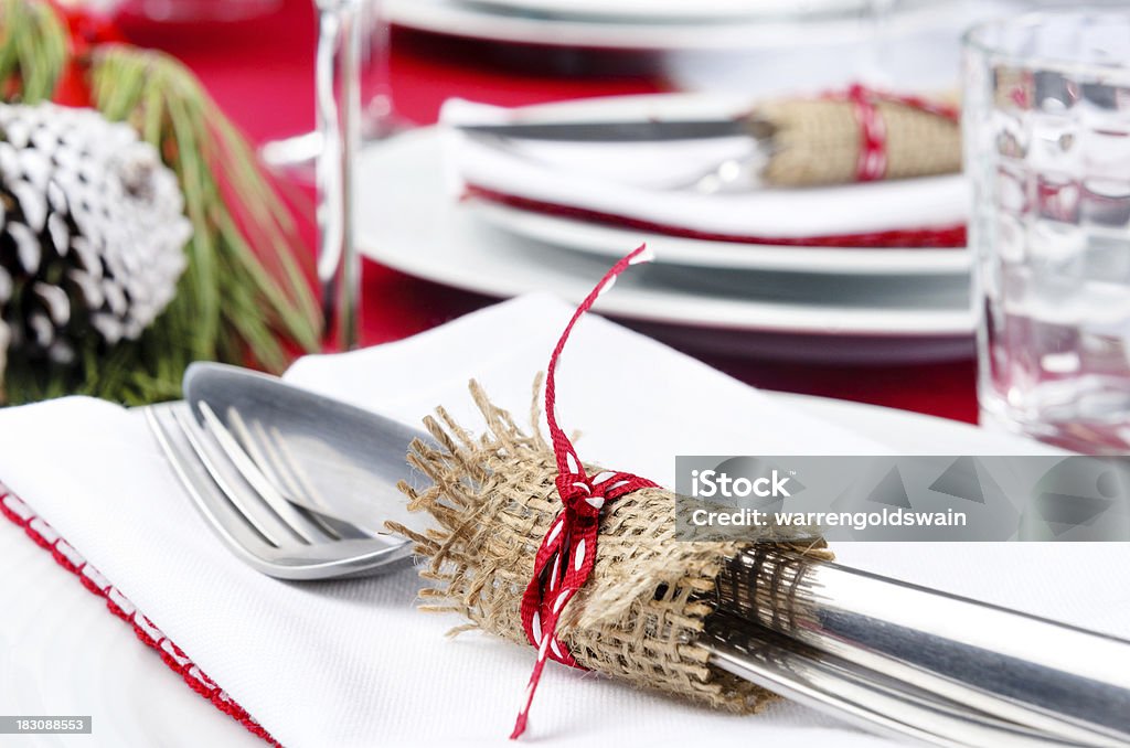 Dinner cutlery for christmas festive season Festive holiday dinner setting, white napkins, crockery, cutlery tied with hessian ribbon detail Arranging Stock Photo