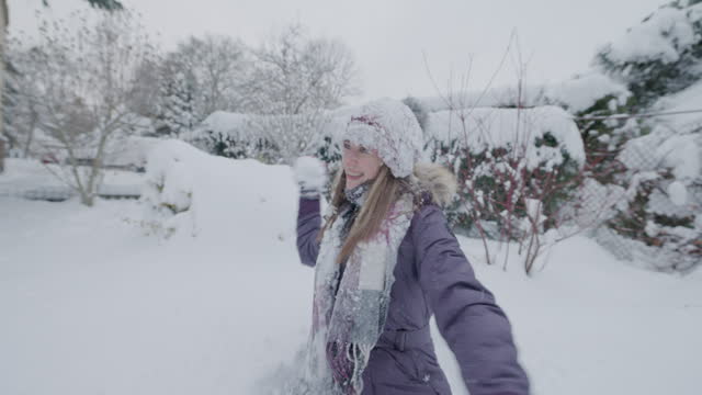 Teenage kids are having snow fight in winter backyard