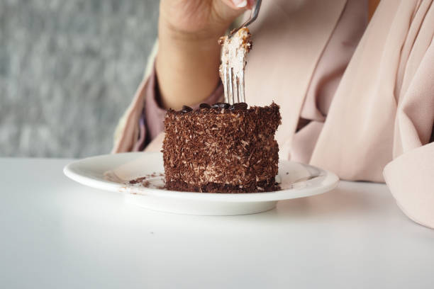 istock women eating chocolate and cream cake on a plate on table 1830901314