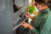 Woman setting oven temperature