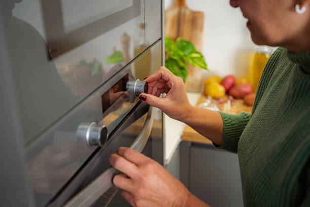 istock Woman adjusting oven temperature knob 1830905194