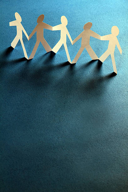 istock Group of paper people holding hands. Teamwork concept 183090522