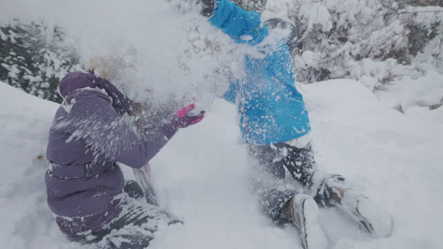 Teenage kids are having snow fight in winter backyard