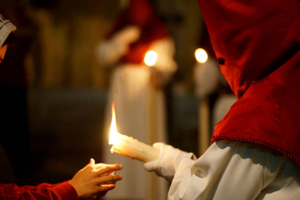 istock A Nazarene on an Easter night with a candle and a child's hand 1830910087