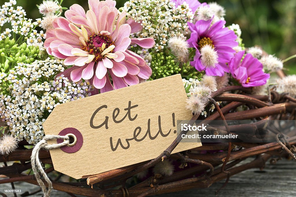 Arrangement of flowers and twigs with Get Well message pink flowers and card with lettering get well Get Well Card Stock Photo