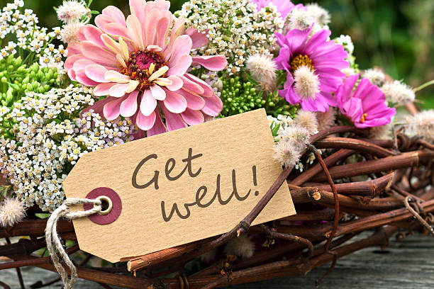 Arrangement of flowers and twigs with Get Well message pink flowers and card with lettering get well get well soon stock pictures, royalty-free photos & images