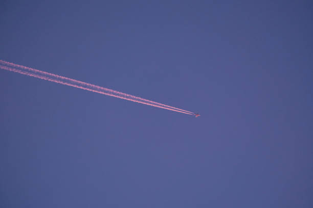 Beautiful pink diagonal of jet contrails at sunset