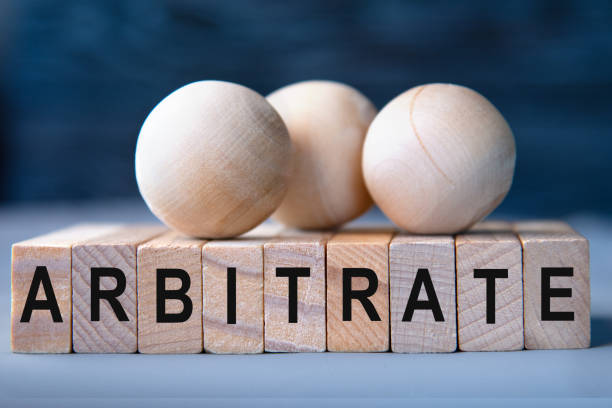 istock ARBITRATE - word on wooden blocks on dark blue background 1830940608
