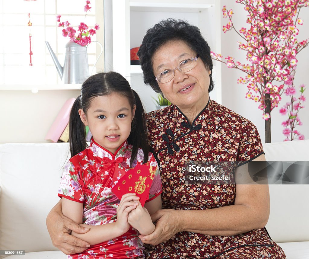 Celebrate Chinese new year. Beautiful grandparent and grandchild celebrate Chinese new year at home. Active Seniors Stock Photo