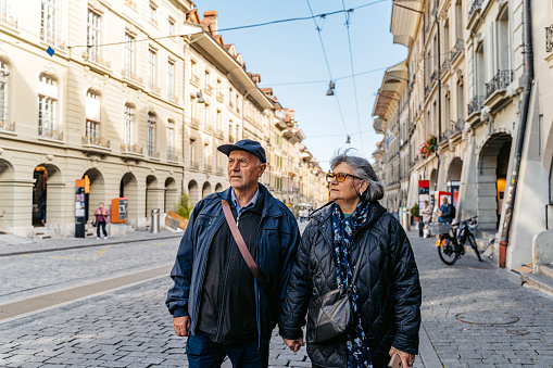 Senior couple walking down the city square and exploring Bern in Switzerland.