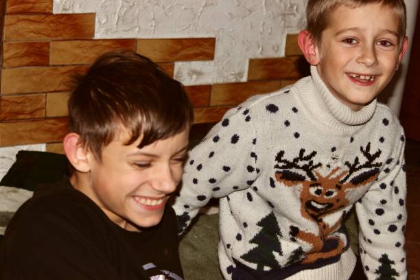 Two cute teenage brothers laugh merrily and rejoice while discussing something