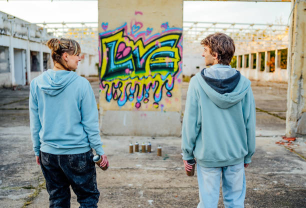 istock Young friends standing in front of a graffiti wall 1831058122