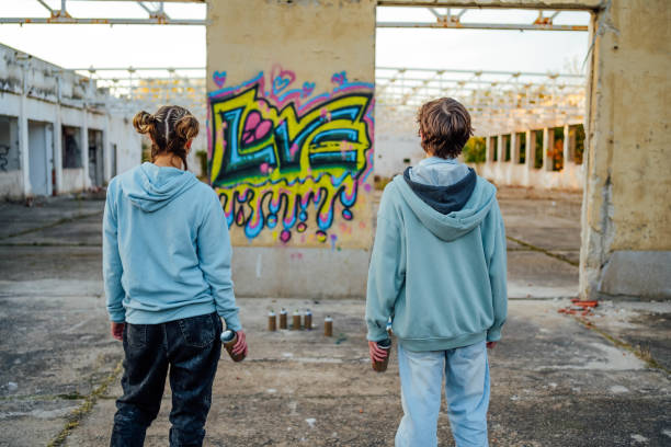 istock Young friends standing in front of a graffiti wall 1831058130