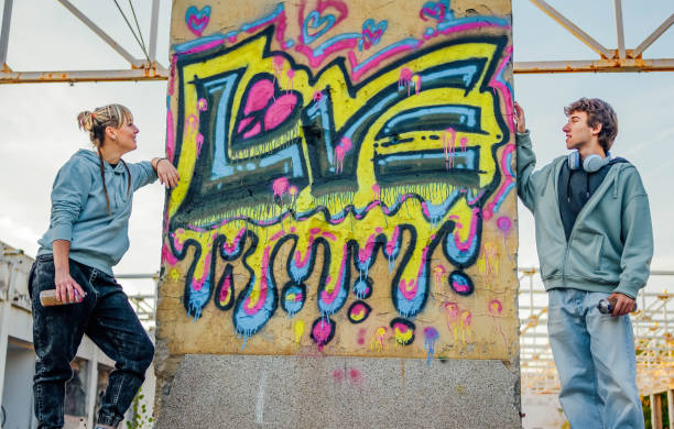 istock Young friends standing in front of a graffiti wall 1831060249