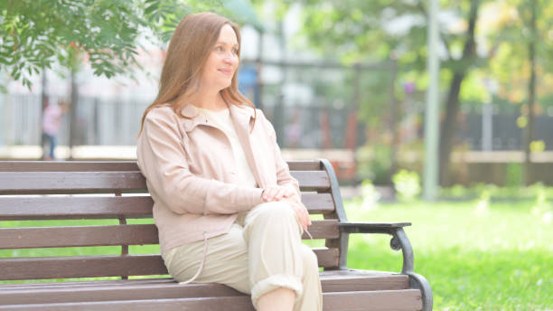 istock Senior Old Woman Coming and Sitting on Bench 1831069200