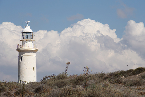 Paphos 19th century Lighthouse upon a hillside, Cyprus, October 04 2015, with clouds in the background.