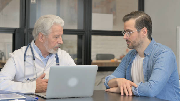 istock Senior Doctor Talking with Patient in Clinic 1831103871