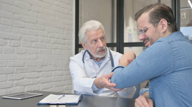 istock Orthopaedic Senior Doctor Checking Man with Elbow Pain 1831109739