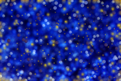 Blue blurred background with glittering snowflakes and dots