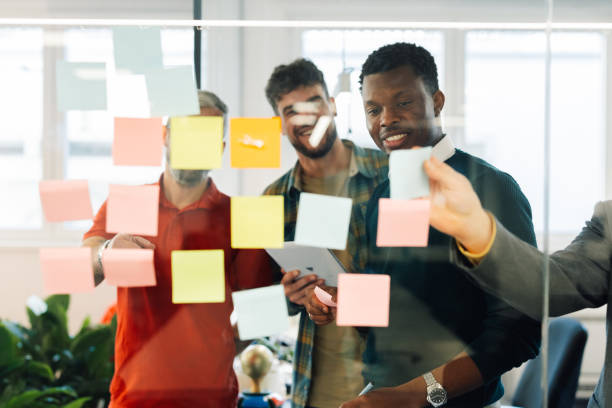 istock View through the glass of a businesspeople sharing ideas on sticky notes. 1831155331