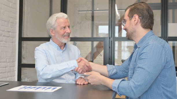 istock Businessman Shakes Hand with Young Man 1831164714